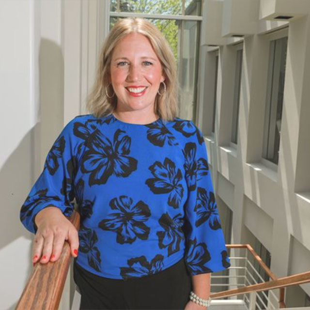 Sarah Perez, Columbus Business First Women of Influence Podcast, photo of Sarah smiling in a blue shirt